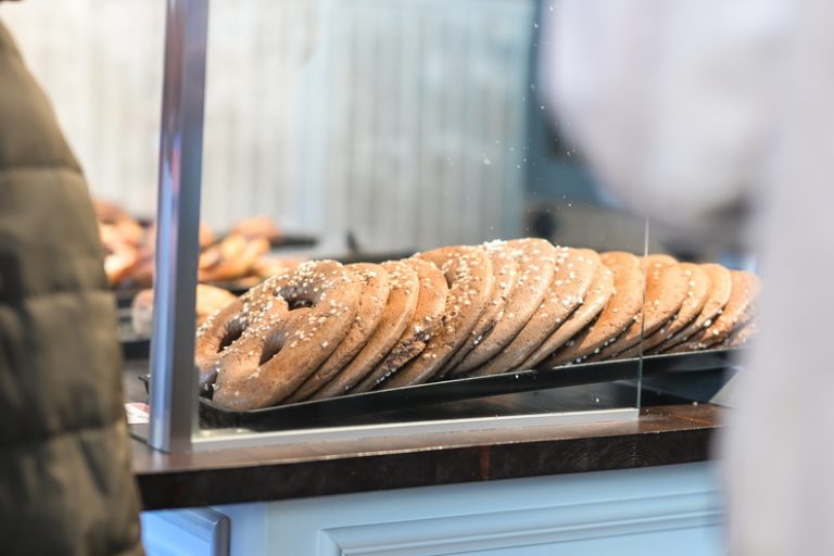Tablett mit großen, gesalzenen Brezeln, ausgestellt hinter einer Glastheke bei Hibbe & Dribbe im Mainzer Kastel – ein Snack, den man bei jeder Kulinarischen Aktiv-Tour unbedingt probieren sollte.