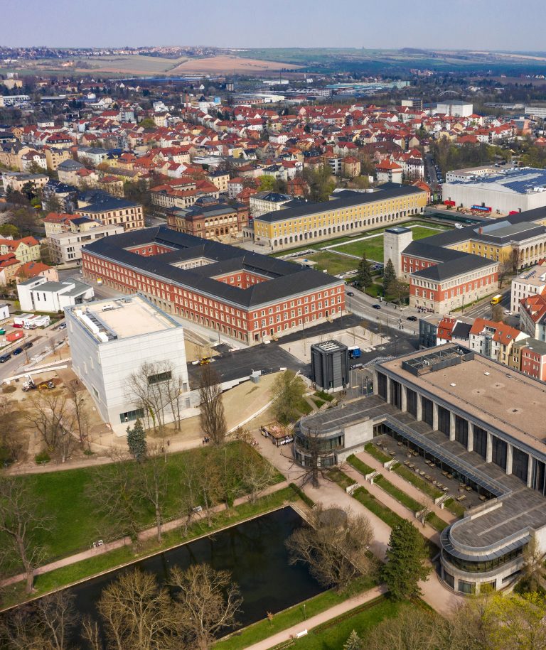 Luftaufnahme eines großen Universitätsgeländes in Weimar mit historischen und modernen Gebäuden in der Nähe des Quartiers der Moderne, umgeben von der Stadt und Grünanlagen.