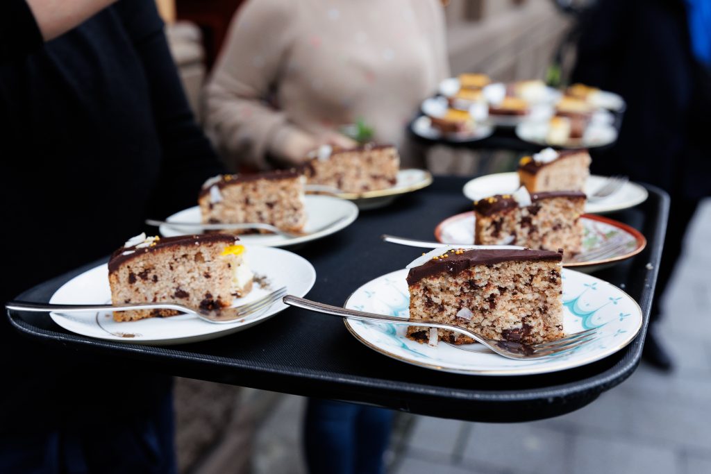 Schokoladenkuchen auf Tellern mit Gabeln wird auf einem Tablett im Freien serviert - perfekt für ein süßes Date in Hamburg oder als Inspiration für charmante date ideen in hamburg.
