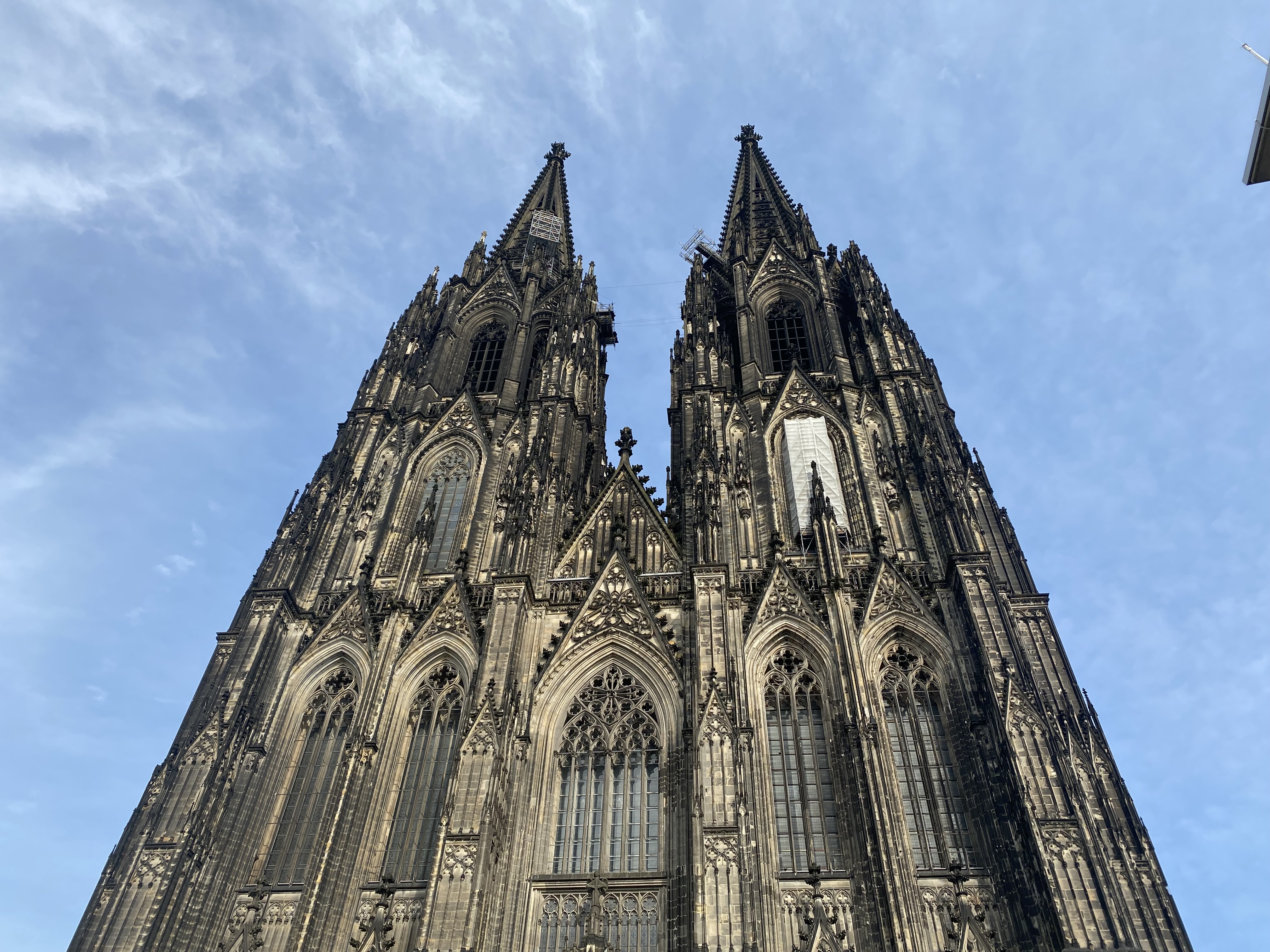 Die gotische Kathedrale mit zwei hohen Türmen vor blauem Himmel - perfekt für einen Spaziergang durch Köln und die Entdeckung des schönen Viertels Köln.