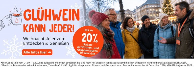 Eine Gruppe von Menschen mit Tassen steht lächelnd auf einem Weihnachtsmarkt unter festlicher Beleuchtung und Dekoration.